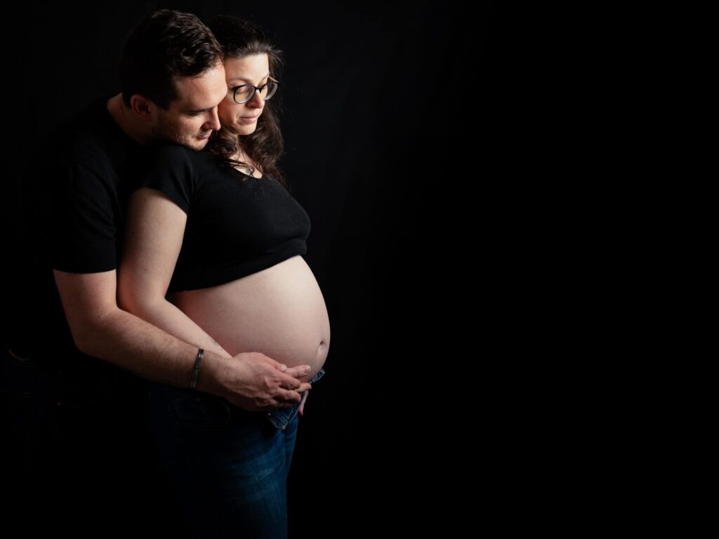 Photo de grossesse d'un couple, la femme à le ventre rond.