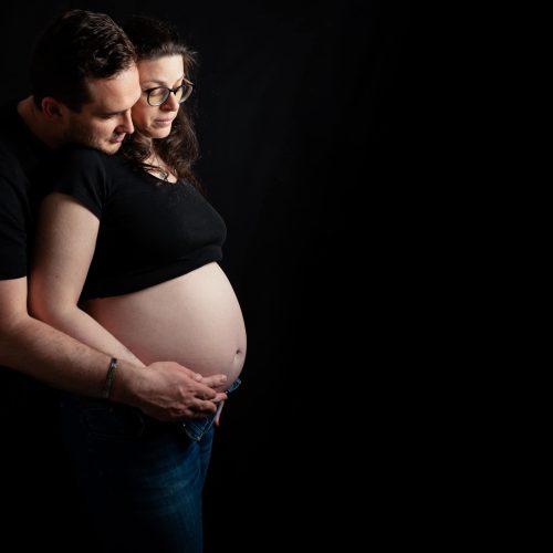 Photo de grossesse d'un couple, la femme à le ventre rond.